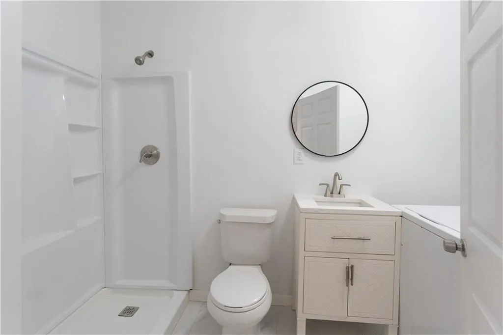 Full bath featuring vanity, a shower stall, and washer / dryer