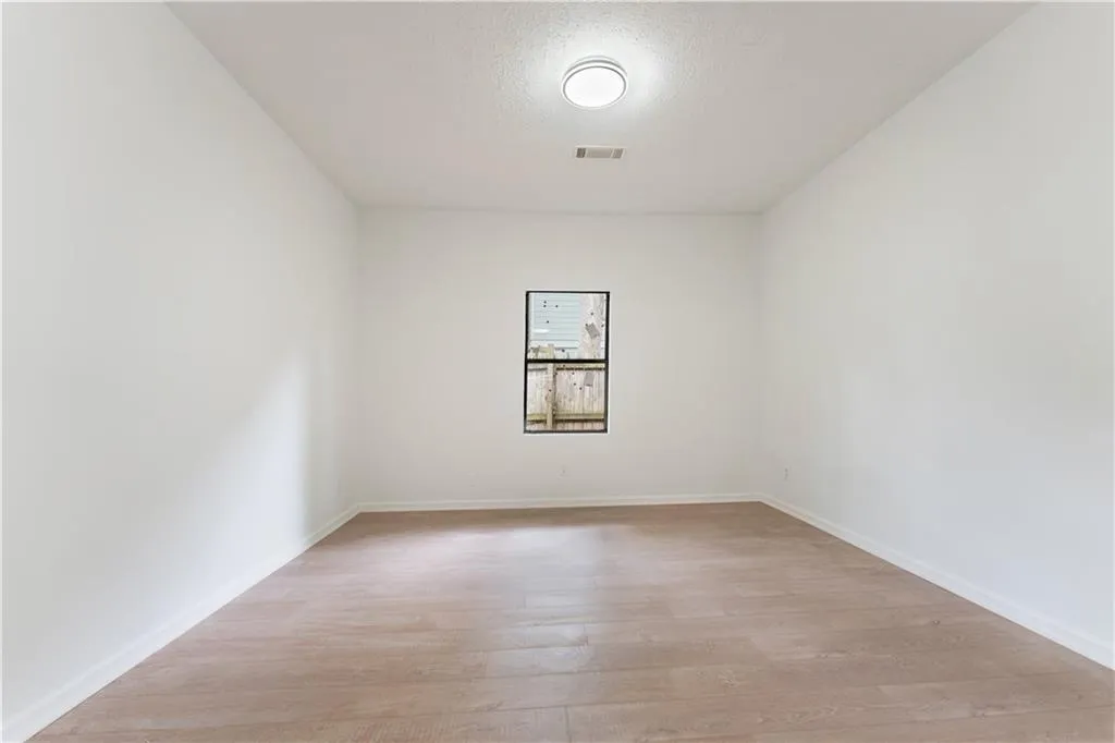 Spare room featuring light wood-type flooring and a textured ceiling
