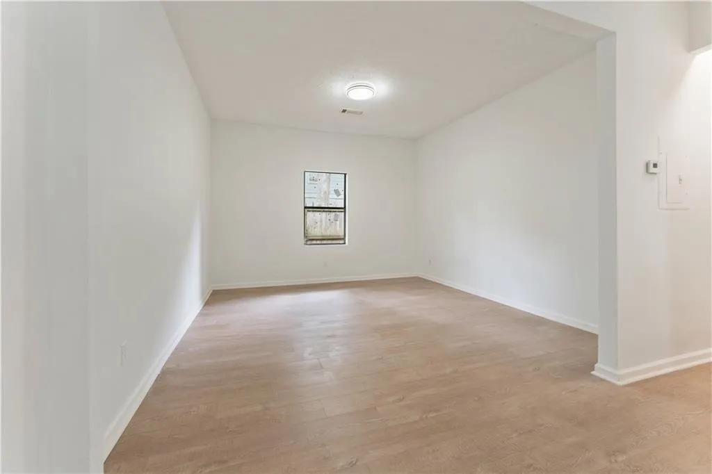 Empty room with light wood-type flooring and baseboards
