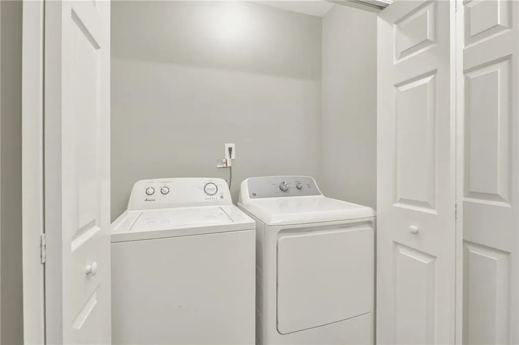 Dedicated laundry alcove featuring a white top-load washing machine and a white front-load dryer