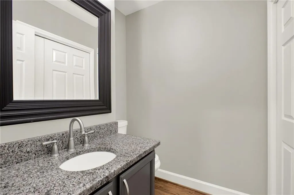 Vanity with a granite countertop, undermount sink, and brushed nickel faucet