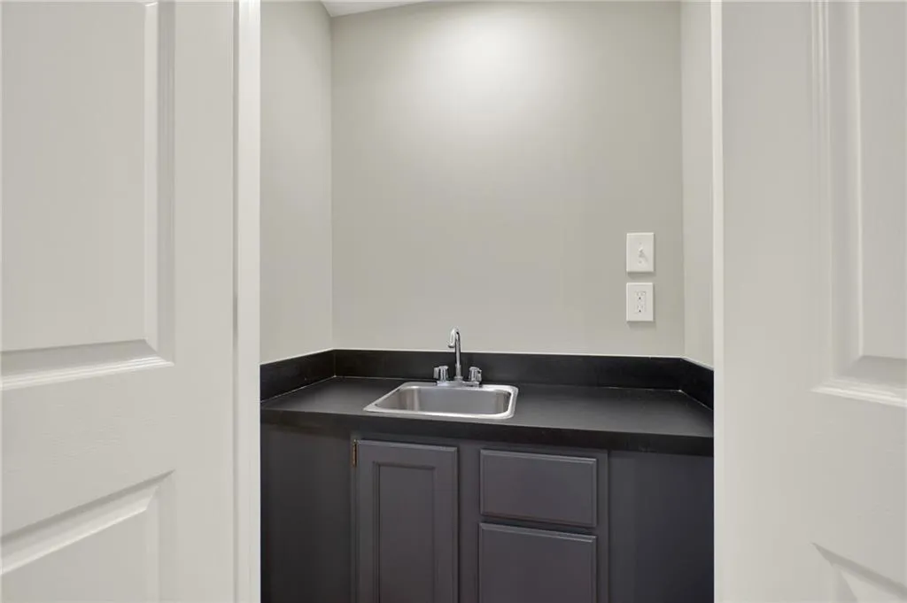 Utility sink set within a dark countertop and base cabinetry
