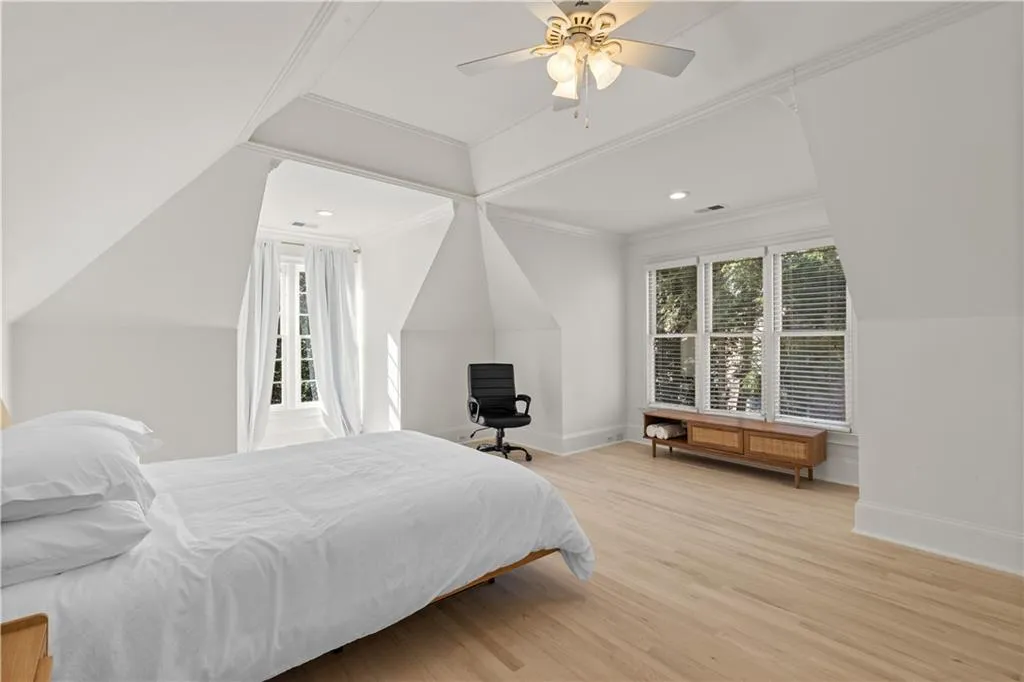 Bedroom with light wood-style flooring, ceiling fan, lofted ceiling, crown molding, and recessed lighting