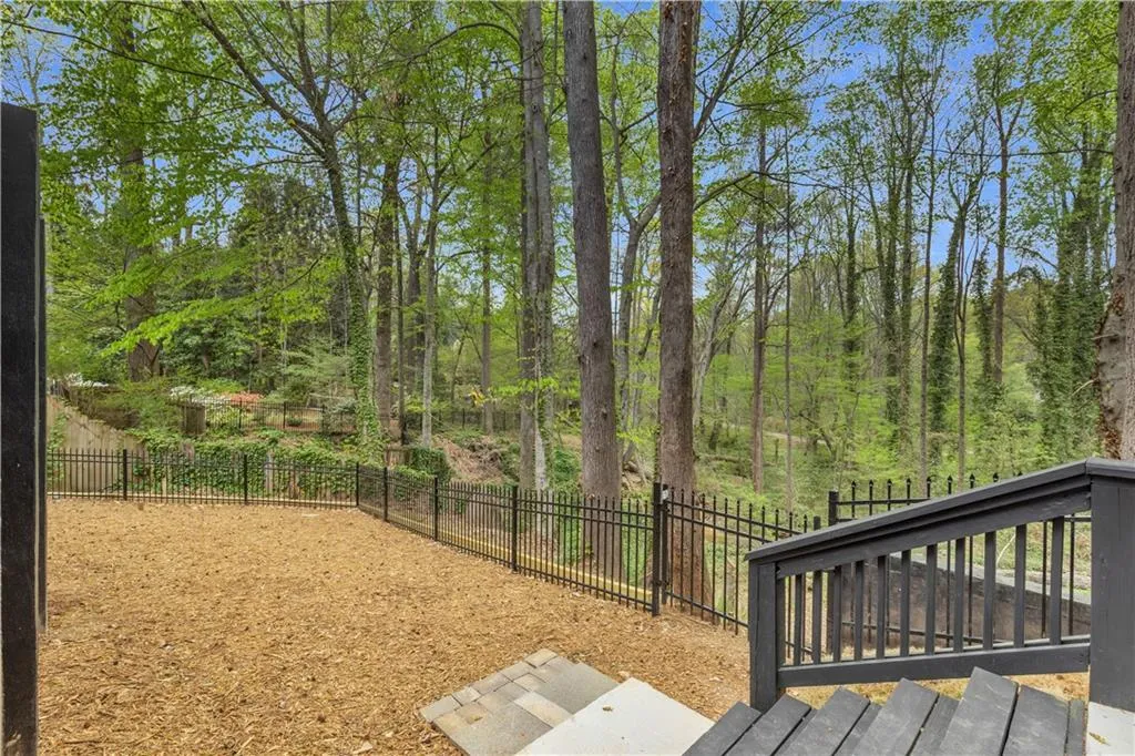Wooden terrace with a fenced backyard