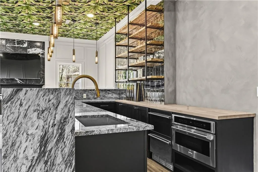 Kitchen with dark cabinetry, stainless steel oven, decorative light fixtures, wood counters, and open shelves