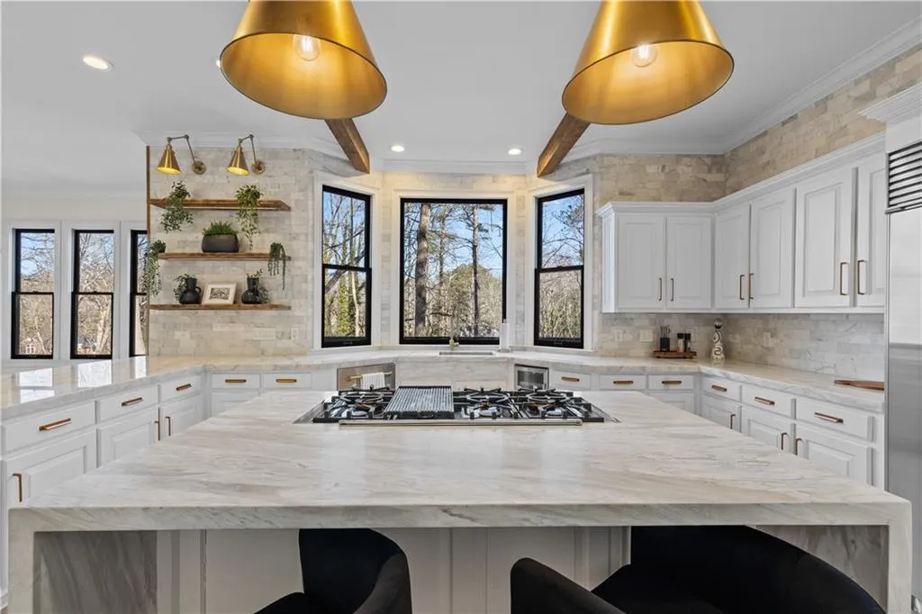 Kitchen featuring light stone countertops, crown molding, plenty of natural light, white cabinetry, and recessed lighting