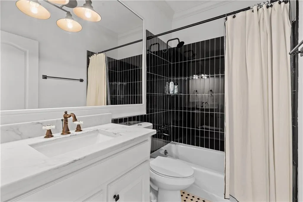 Bathroom with vanity, crown molding, and shower / bathtub combination with curtain