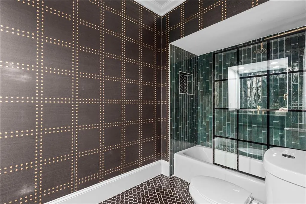 Bathroom featuring combined bath / shower with glass door and ornamental molding