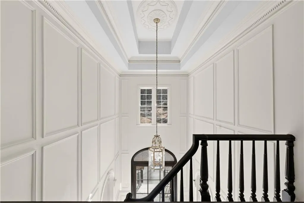 Staircase featuring hanging lights and a decorative wall