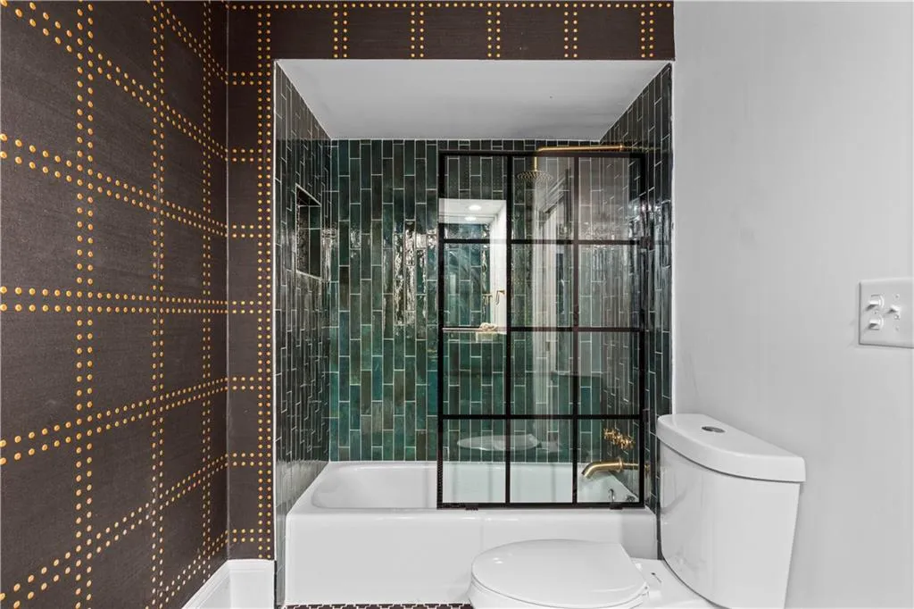 Bathroom with toilet and enclosed tub / shower combo