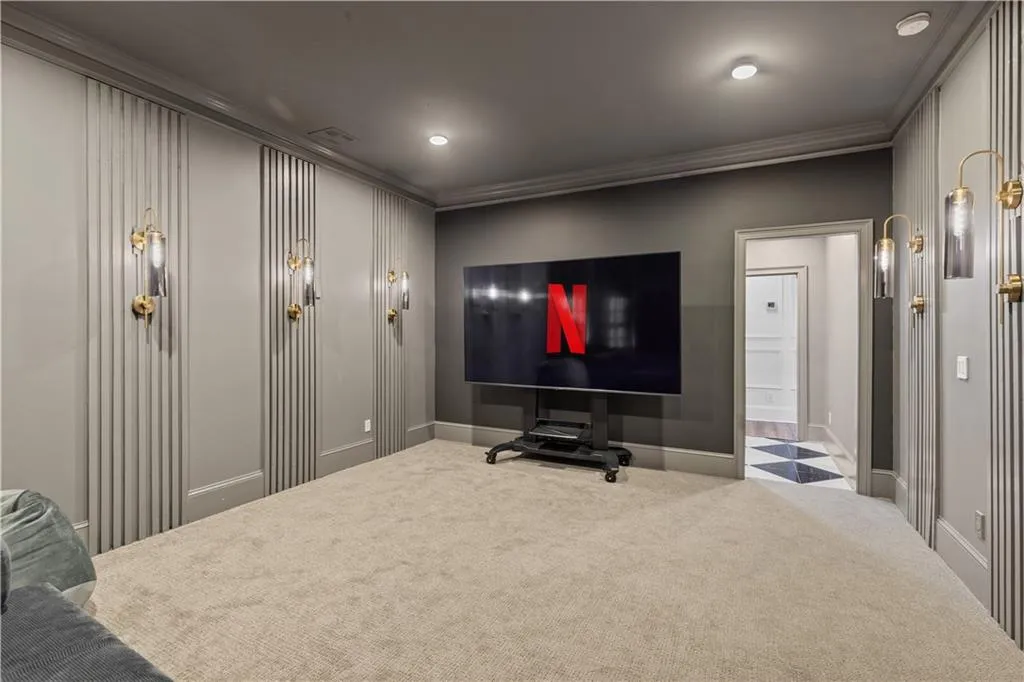 Carpeted home theater room featuring ornamental molding and recessed lighting
