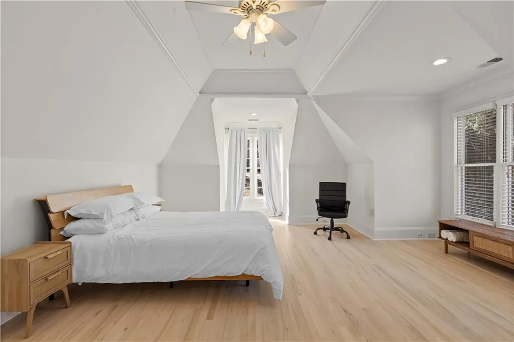 Bedroom featuring light wood-type flooring, ceiling fan, lofted ceiling, crown molding, and recessed lighting