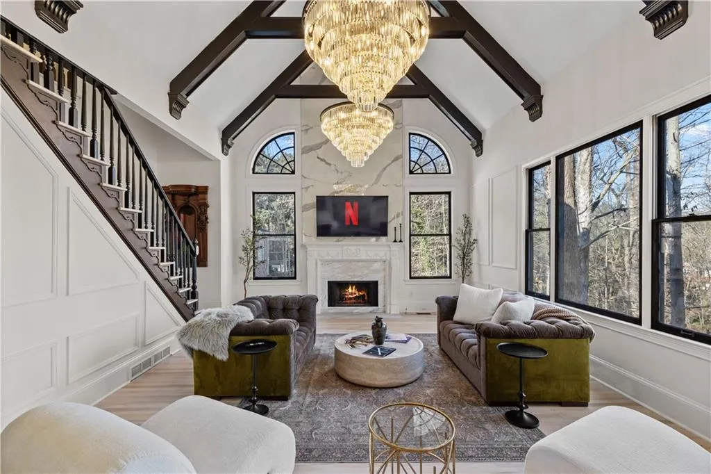 Living room with a premium fireplace, a chandelier, and wood finished floors