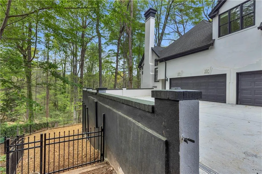 View of home's exterior with stucco siding, a chimney, and driveway