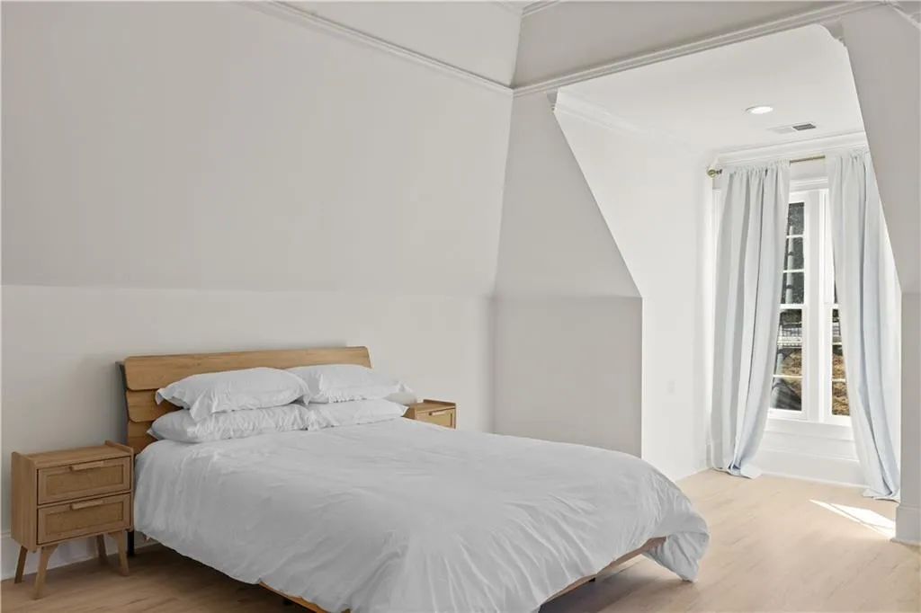 Bedroom with light wood finished floors, vaulted ceiling, and recessed lighting