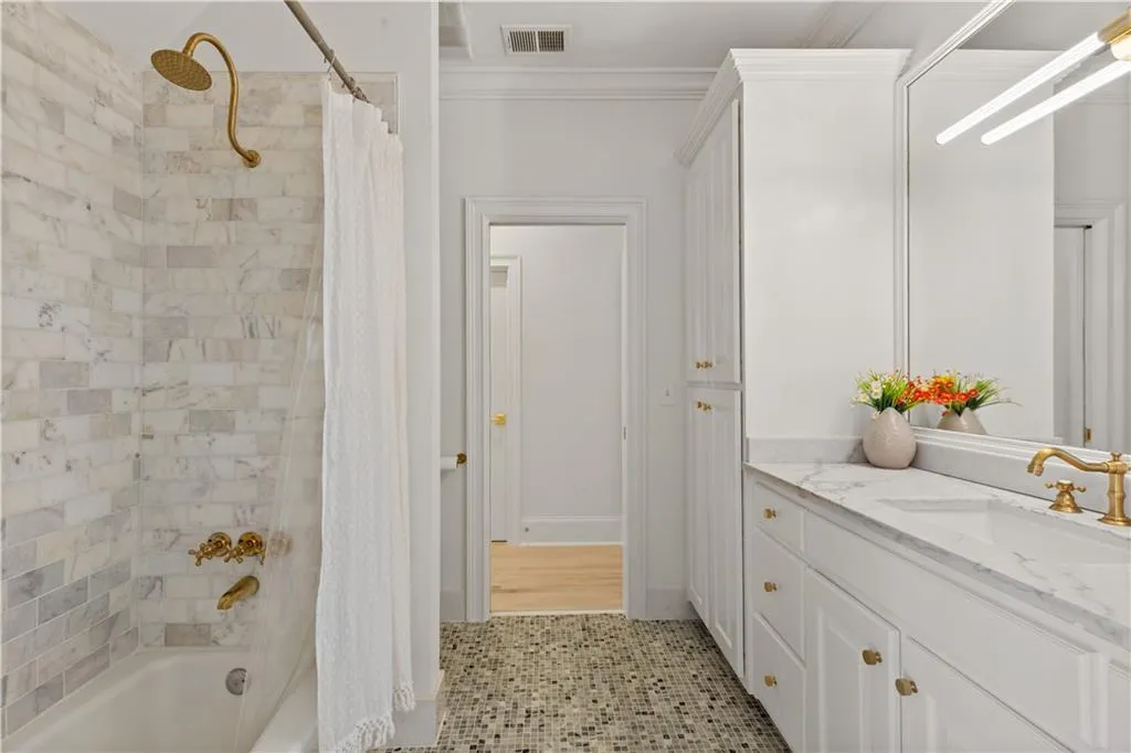 Bathroom with vanity, shower / tub combo, light tile patterned floors, and ornamental molding