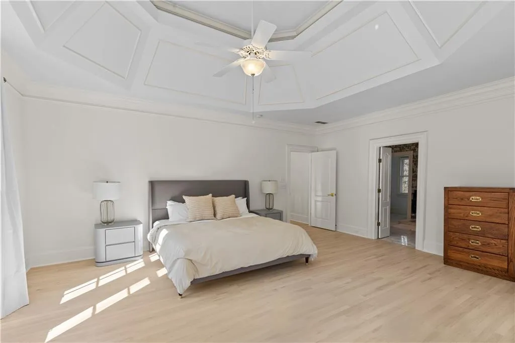 Bedroom featuring light wood-type flooring, ceiling fan, and ornamental molding
