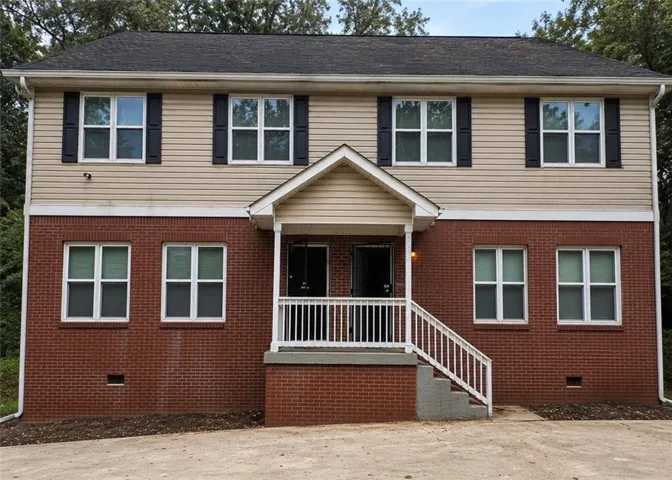 Two-story facade featuring a brick lower level and horizontal siding upper level