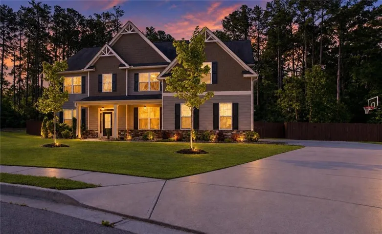 Two-story residence featuring gabled rooflines, a covered front porch, and stone accents