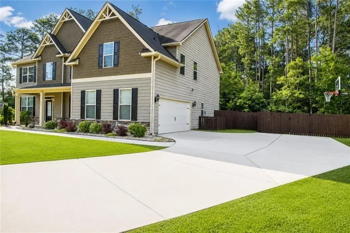 Two-story residence featuring a gabled roofline, mixed siding, and a covered front porch