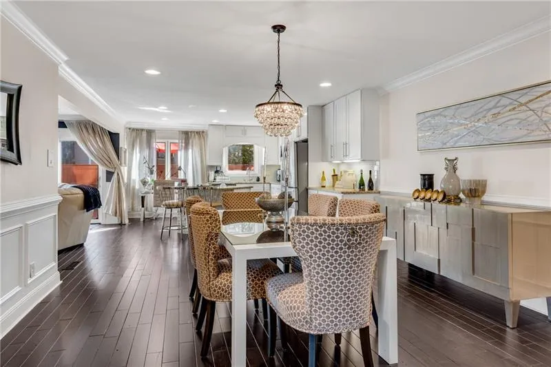 Dining room with an inviting chandelier, dark wood-type flooring, and ornamental molding