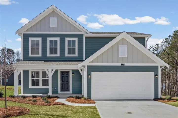 Traditional-style home with board and batten siding, roof with shingles, covered porch, concrete driveway, and a front lawn