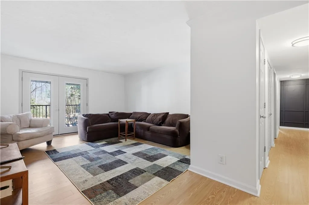 Living room featuring light wood-style floors, ornamental molding, and french doors