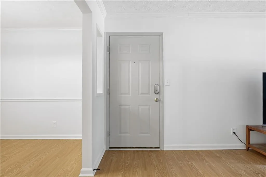 Entryway featuring light wood-style floors and ornamental molding