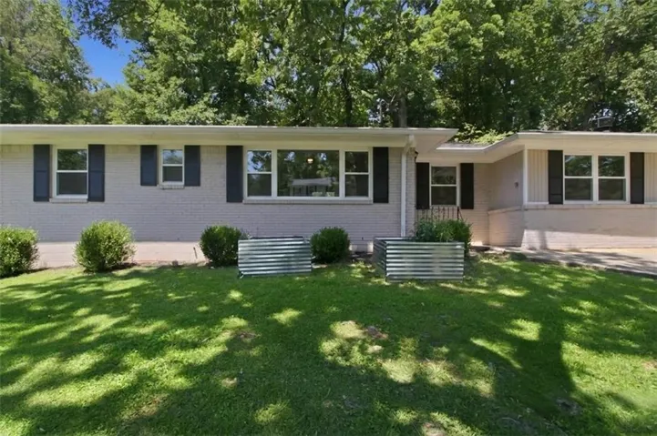 Light gray brick exterior with black window shutters