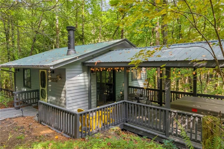 Charming cabin exterior tucked privately among mature hardwoods.