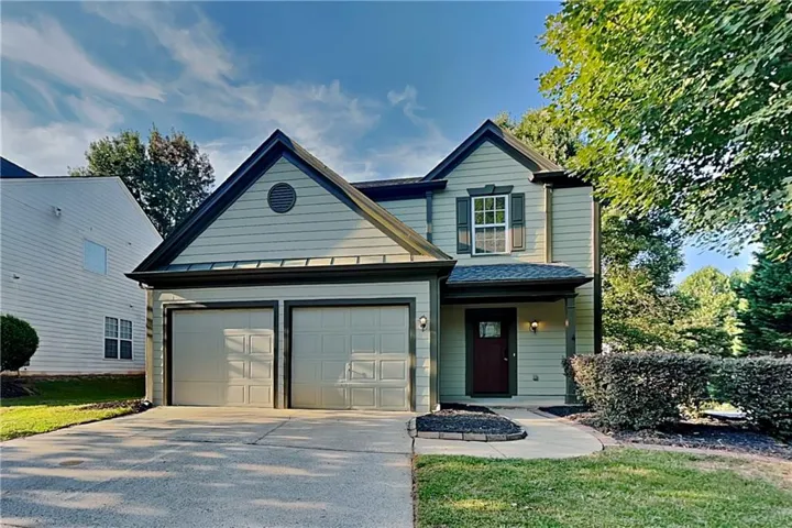Two-story exterior with light-colored siding, dark trim, and a prominent gable roofline