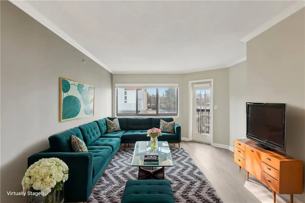 Living room with ornamental molding and light wood-type flooring