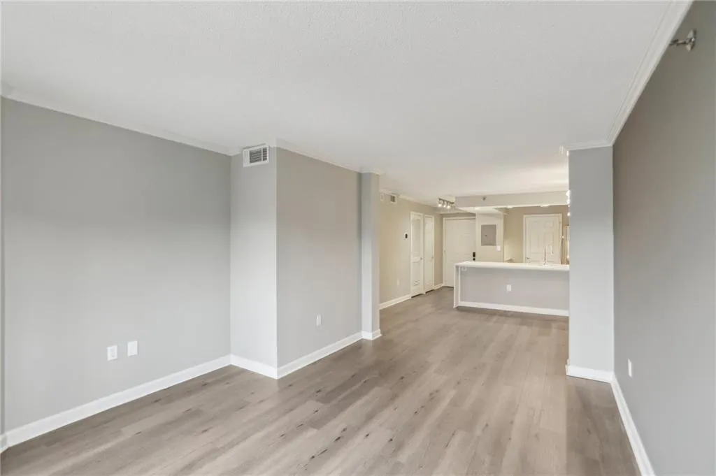 Unfurnished living room featuring crown molding and light hardwood / wood-style floors