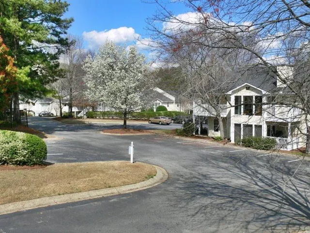 View of asphalt road featuring a residential view and curbs