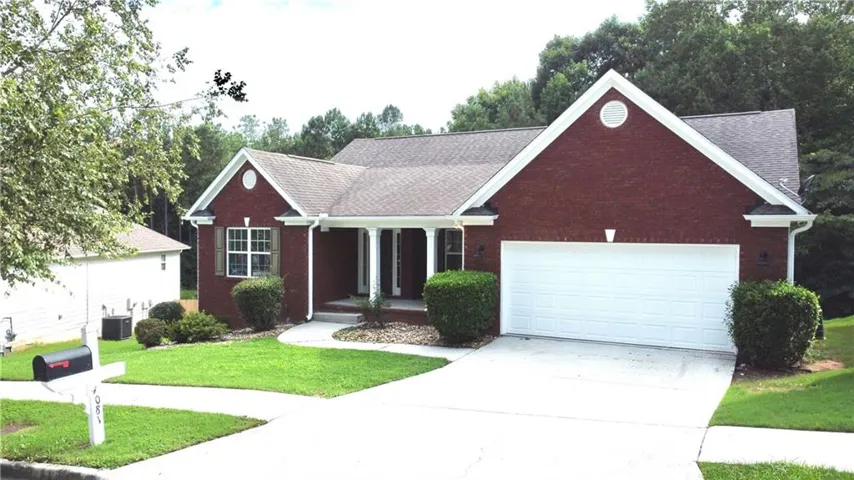 Brick exterior with white trim, featuring a covered entry porch supported by white columns