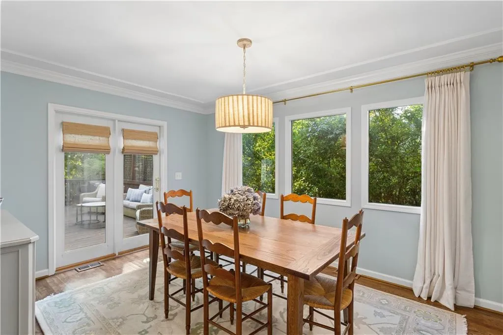 Dining space featuring a drum pendant light, crown molding, multi-pane windows, and glass-paneled double doors providing outdoor access