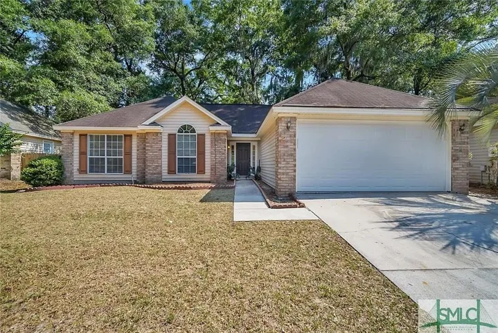Brick veneer accents, decorative shutters, arched window, attached two-car garage, and concrete driveway