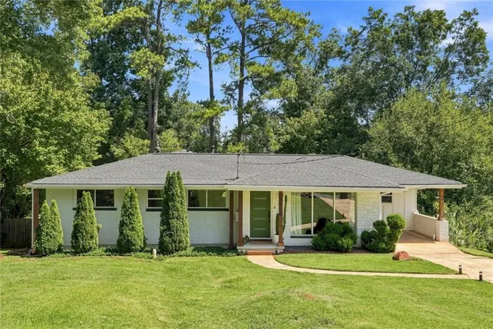 Single-story residence featuring a gray shingle roof, white exterior siding, and a vibrant green front door