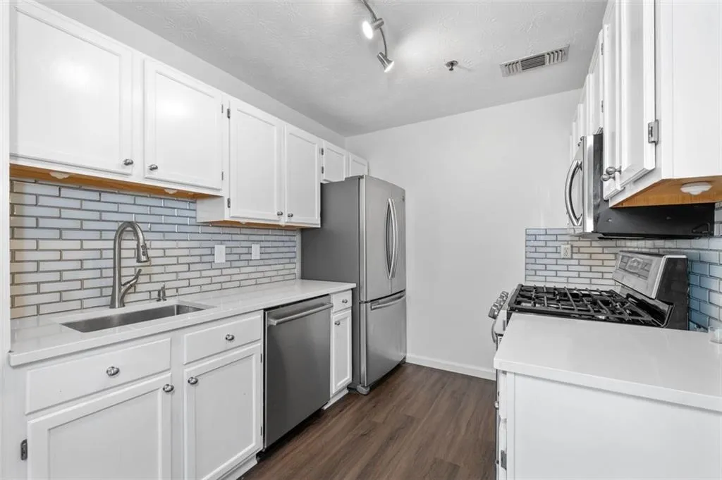 Renovated Kitchen with SS Appliances, Quartz counter-tops, and tile backsplash.