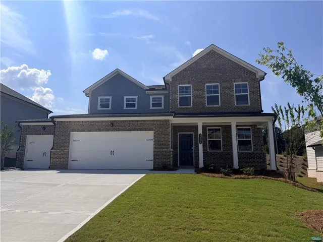 Brick exterior with siding accents, covered entry, attached garage, and a concrete driveway