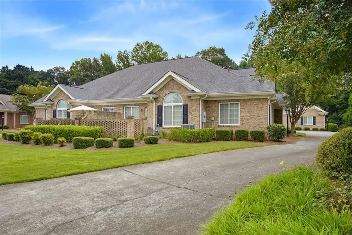 Brick exterior with a dark shingle roof