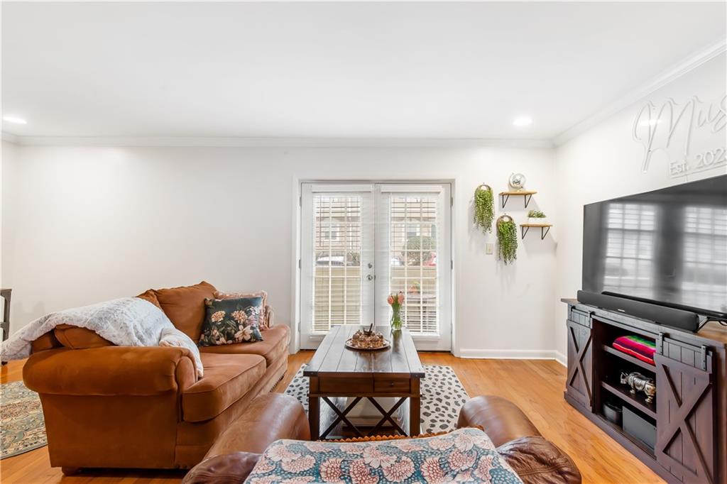 Living room with light hardwood / wood-style floors and ornamental molding