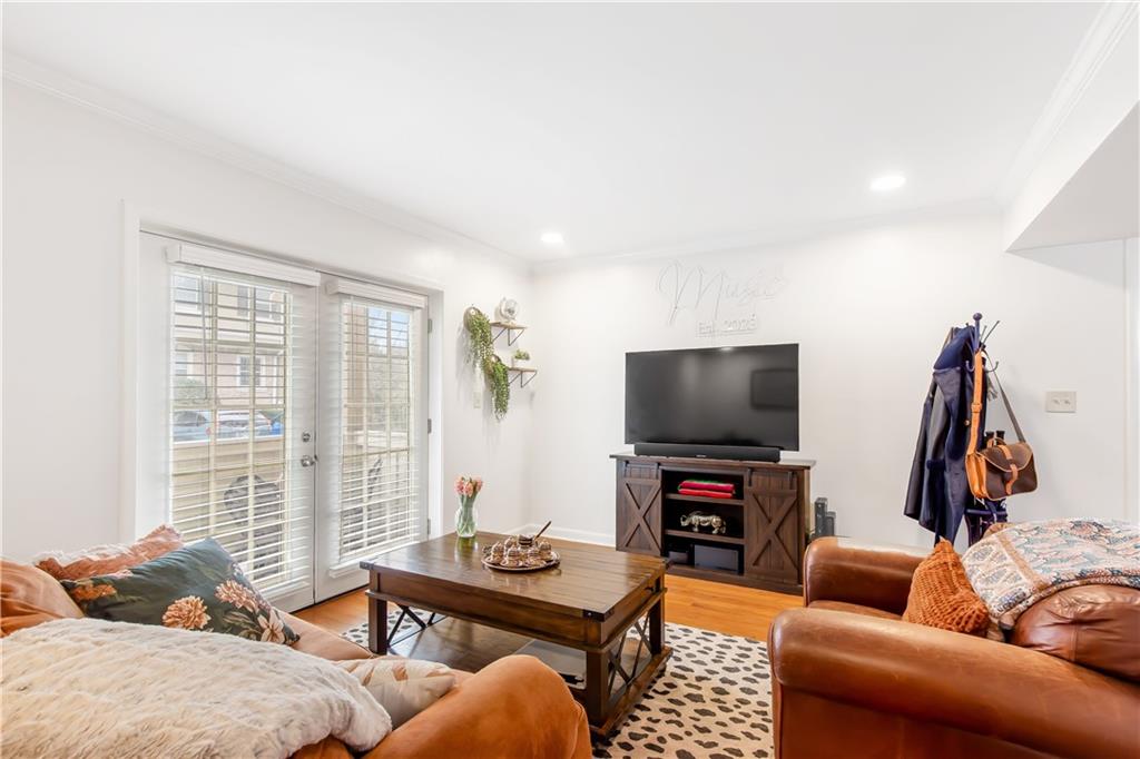 Living room with crown molding and light wood-type flooring