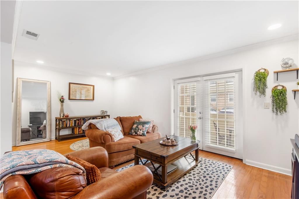 Living room featuring light wood-type flooring and ornamental molding