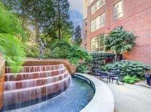 Terraced water feature, brick exterior, lush landscaping, and a paved patio area