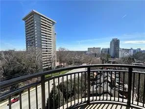 Balcony featuring metal railings and a cityscape backdrop