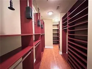 Walk in closet with light wood-type flooring
