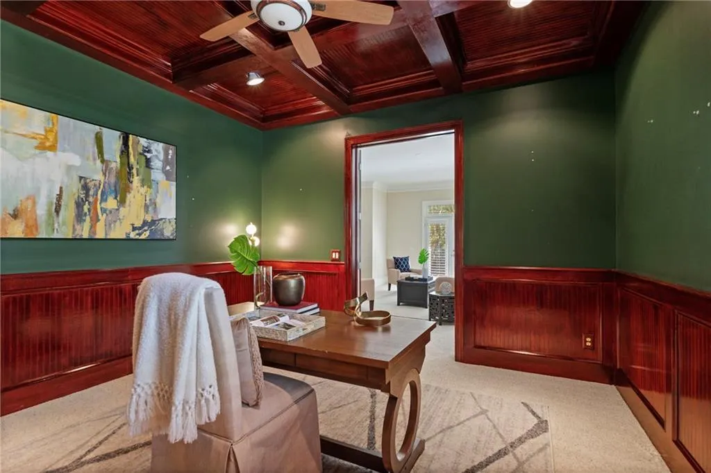 Office space featuring a wooden ceiling with exposed beams, ornamental molding, wainscoting, coffered ceiling, and carpet