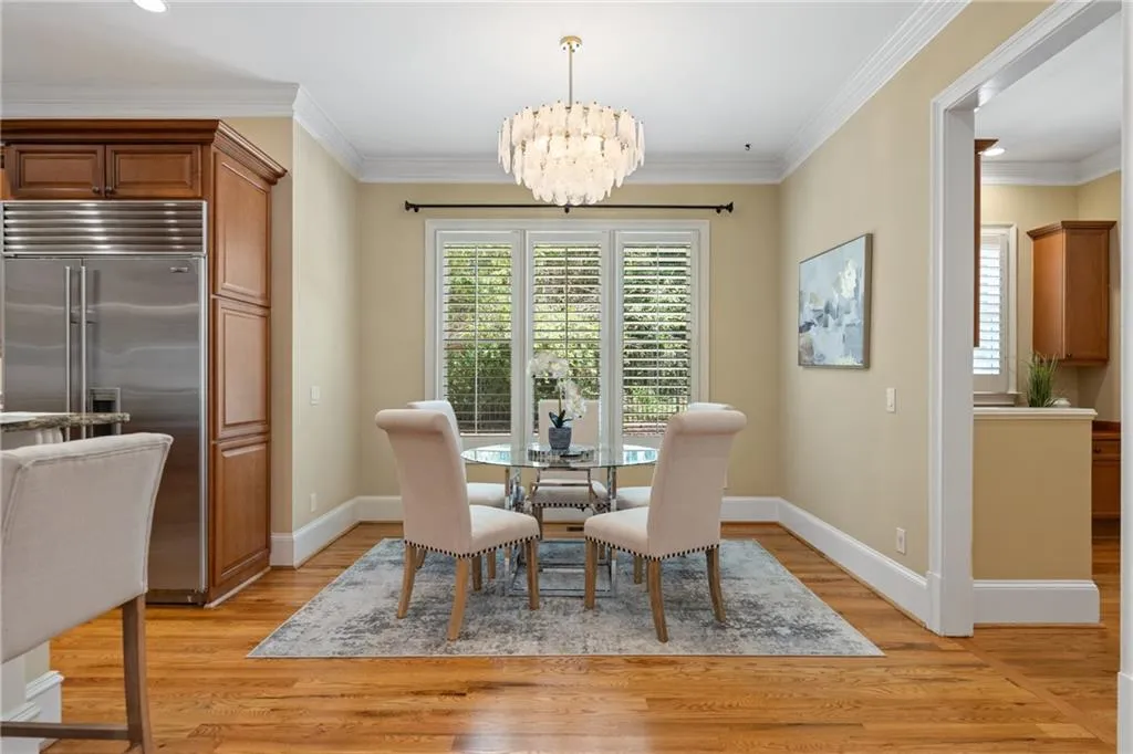Dining area featuring crown molding, a chandelier, and light wood-style flooring