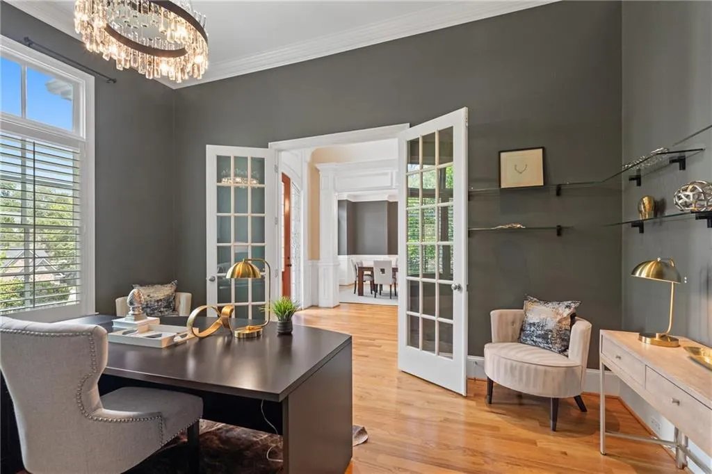 Home office with wood finished floors, a chandelier, crown molding, and french doors